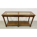 AN OAK FRAMED GLASS TOP SIDE TABLE WITH LOWER OPEN BERGERWARE SHELF W 129CM, D 43CM, H 69CM.