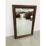 AN ELEGANT REPRODUCTION RECTANGULAR BEVELLED WALL MIRROR IN WALNUT FINISH FRAMEWORK 119CM X 79CM.