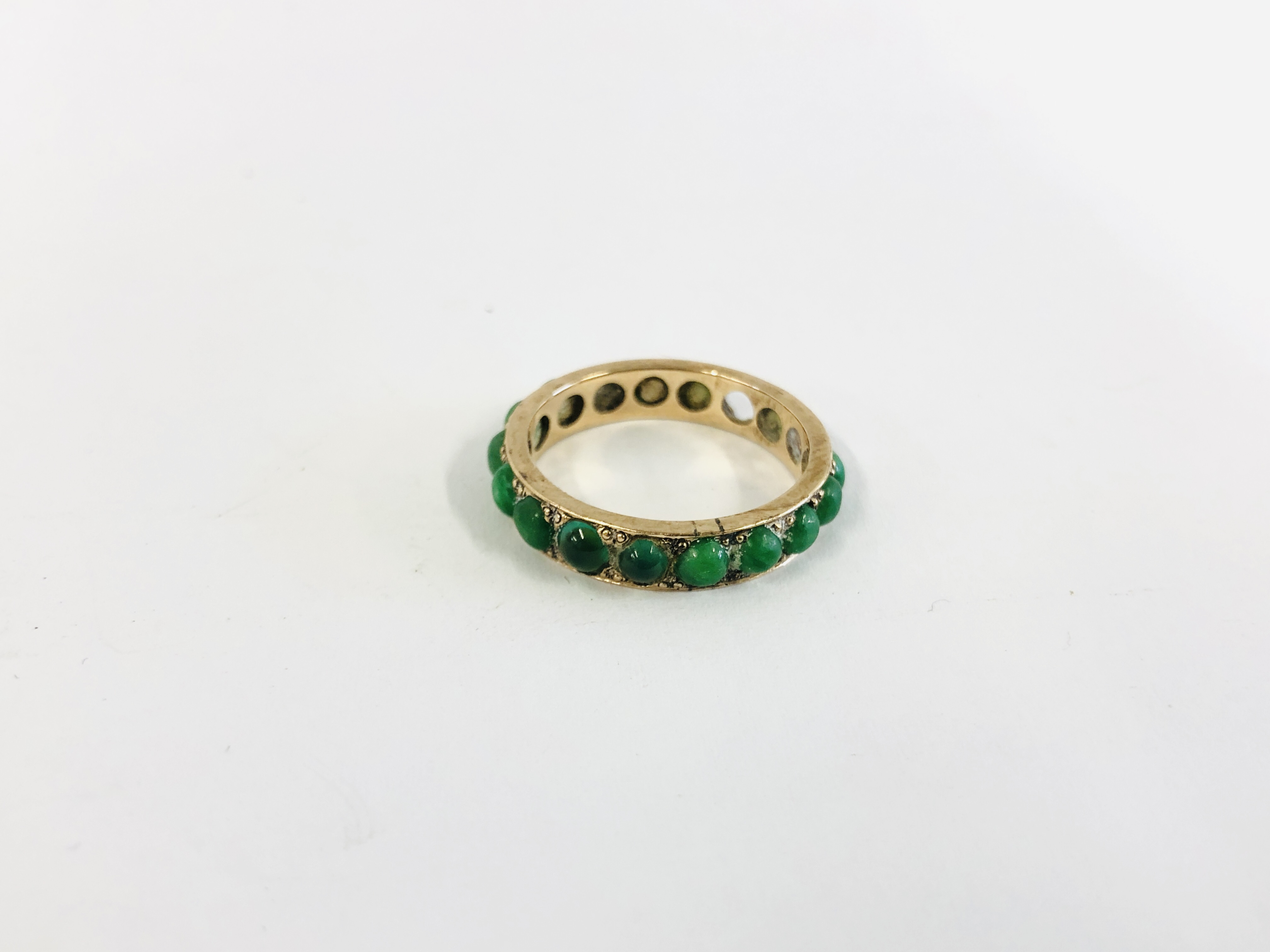 AN UNMARKED YELLOW METAL ETERNITY RING SET WITH JADEITE STONES (2 MISSING) SIZE N/O - Image 4 of 7