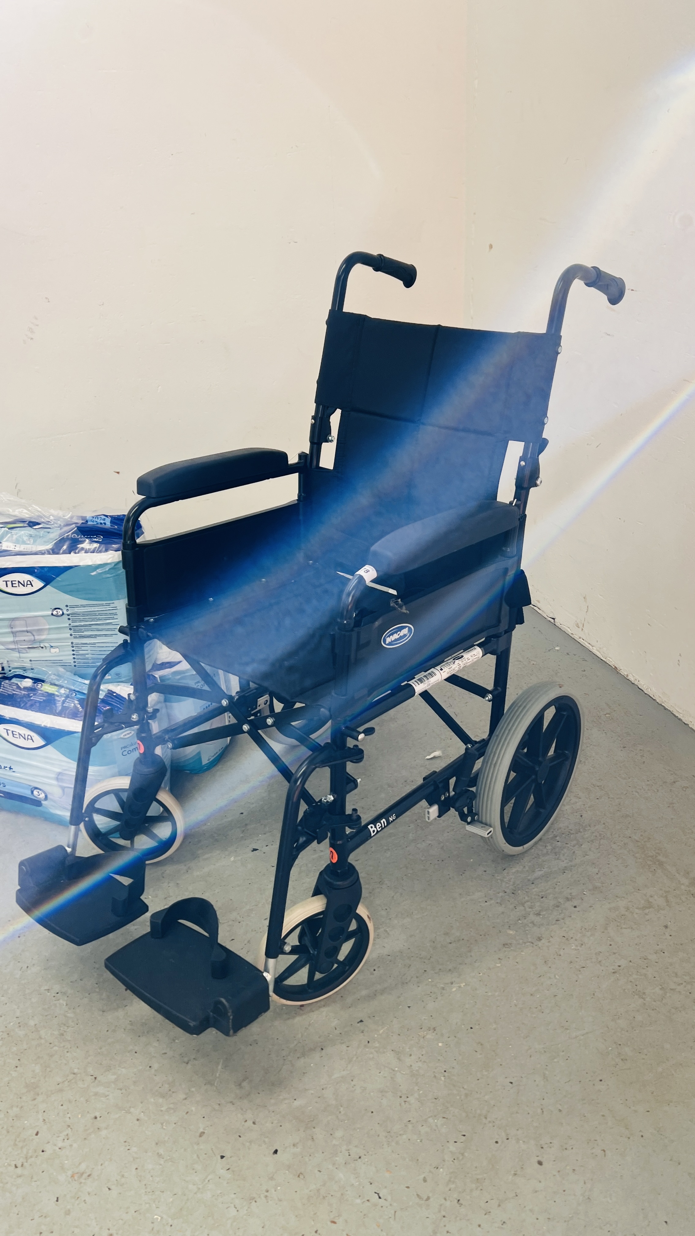 AN INVACARE COLLAPSIBLE WHEEL CHAIR AND THREE PACKS OF TENA PADS - Image 2 of 6