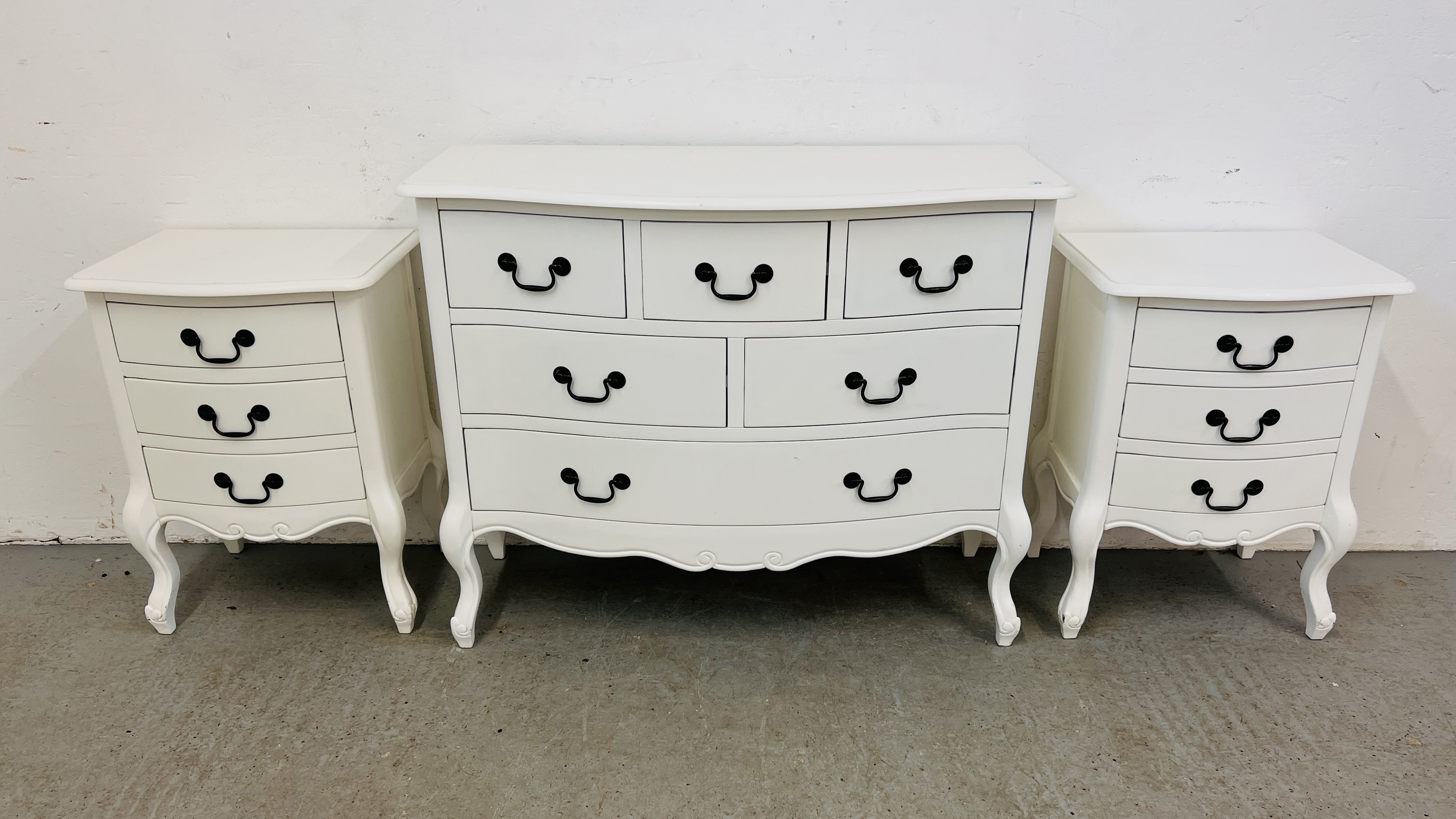 A SIX DRAWER FRENCH STYLE WHITE FINISHED CHEST ALONG WITH MATCHING PAIR OF BEDSIDE CABINETS ALL