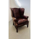 A GOOD QUALITY REPRODUCTION ANTIQUE FINISH TAN LEATHER WING BACKED FIRESIDE CHAIR