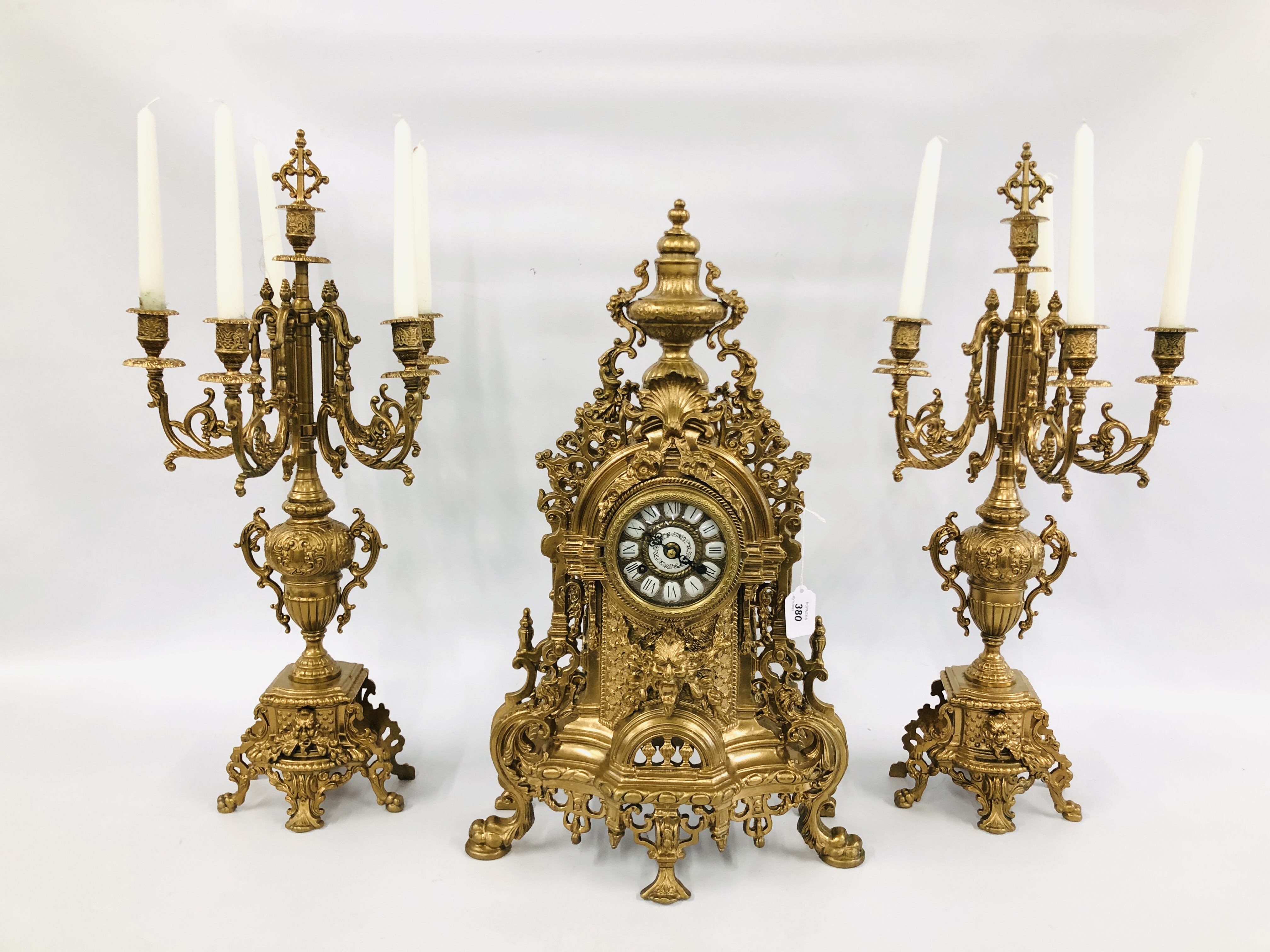 AN IMPRESSIVE CONTINENTAL ORNATE GILT METAL MANTEL TIME PIECE AND PAIR OF SIX POT CANDELABRA