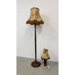 AN OAK FINISH STANDARD LAMP WITH A PHEASANT DECORATED FRINGED SHADE + A HARDWOOD TABLE LAMP AND