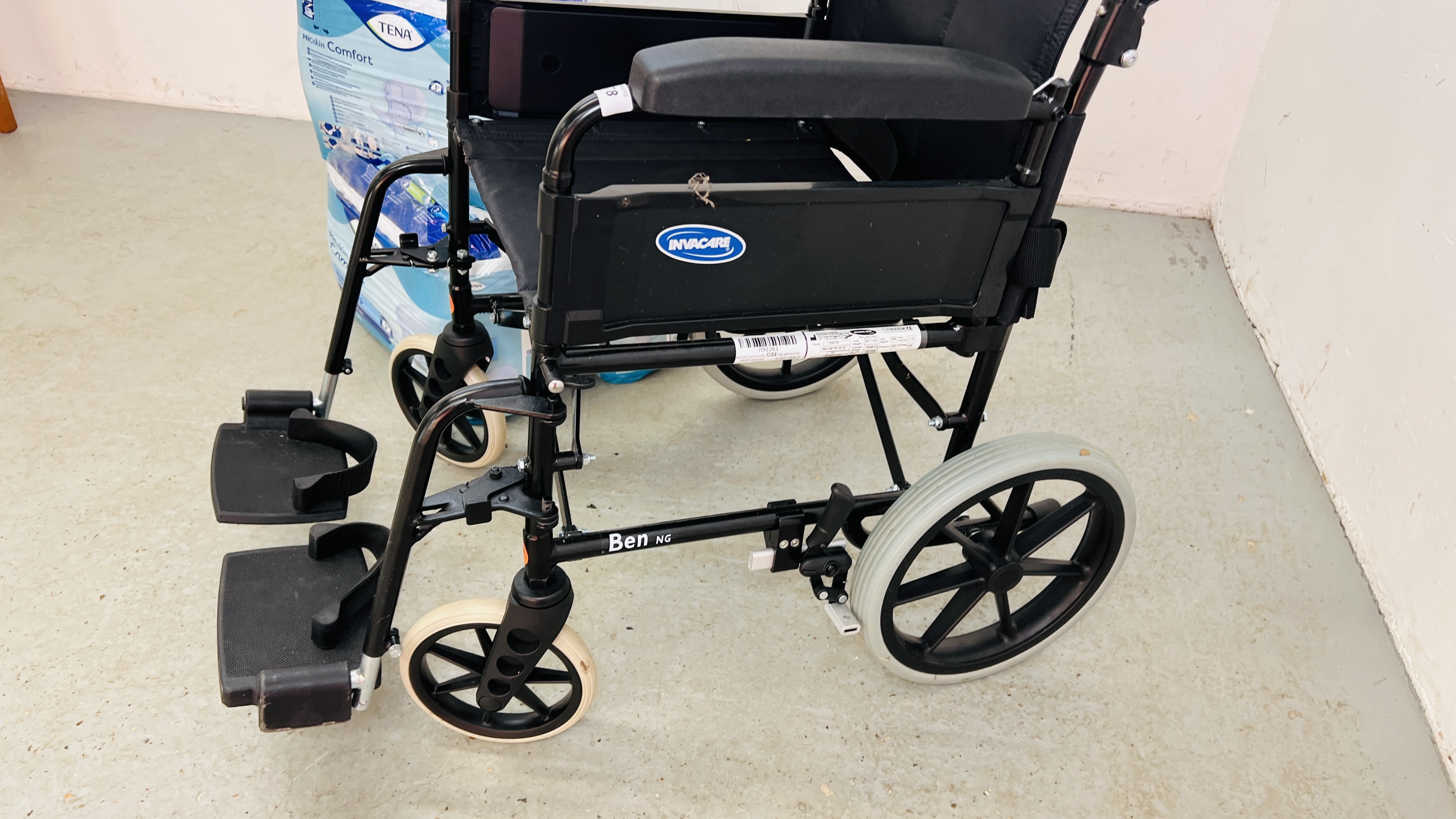 AN INVACARE COLLAPSIBLE WHEEL CHAIR AND THREE PACKS OF TENA PADS - Image 4 of 6