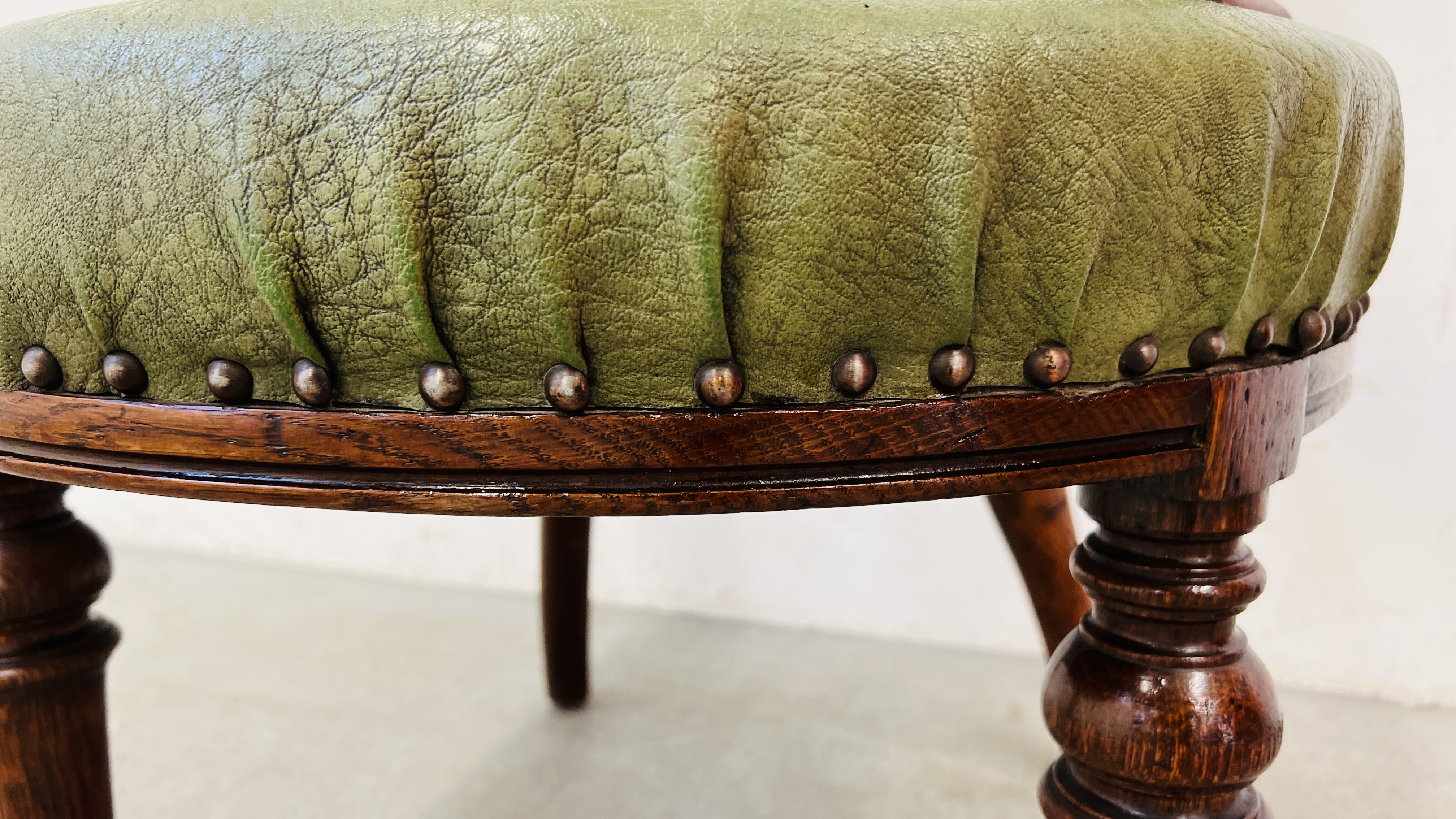 AN ANTIQUE OAK FRAMED TUB CHAIR WITH BOTTLE GREEN LEATHER UPHOLSTERY AND STUD DETAILING. - Image 6 of 7