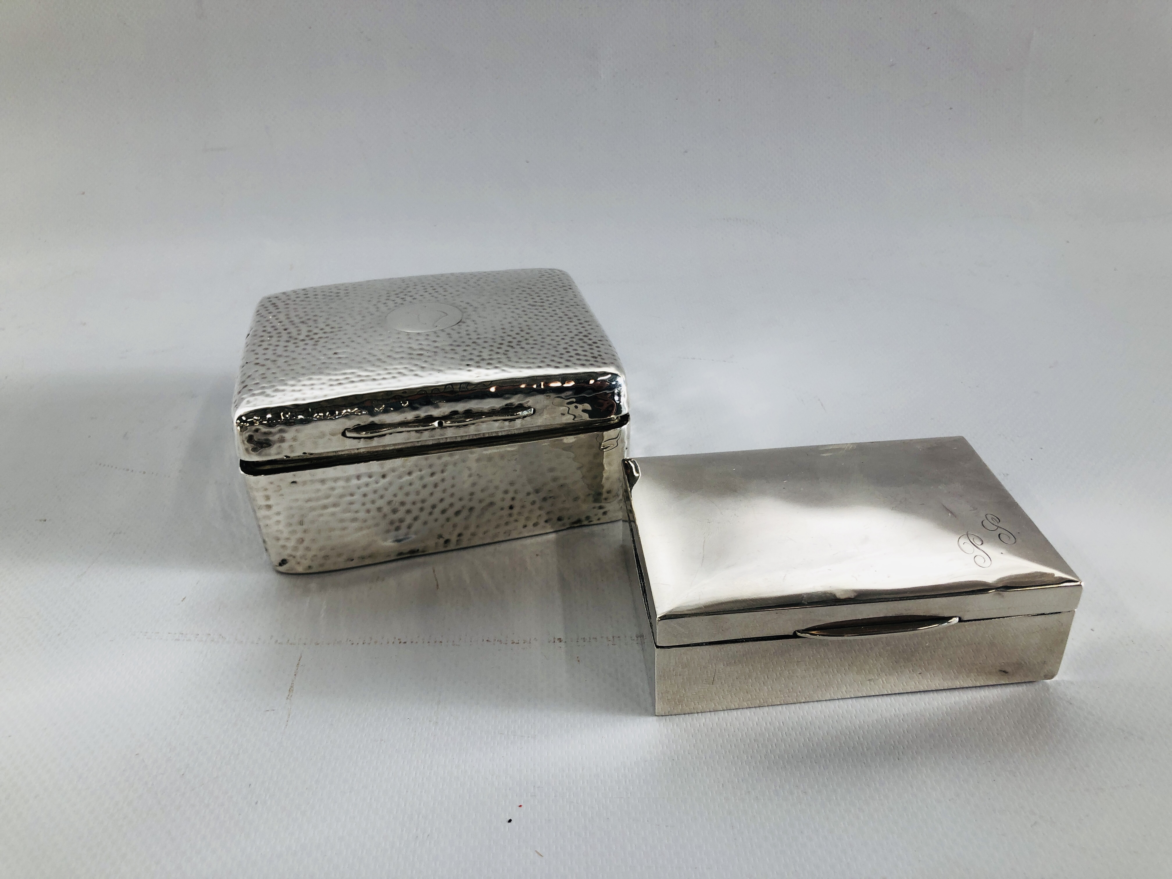 A SMALL SILVER CIGARETTE BOX AND ONE LARGER SILVER CIGARETTE BOX WITH HAMMERED FINISH.