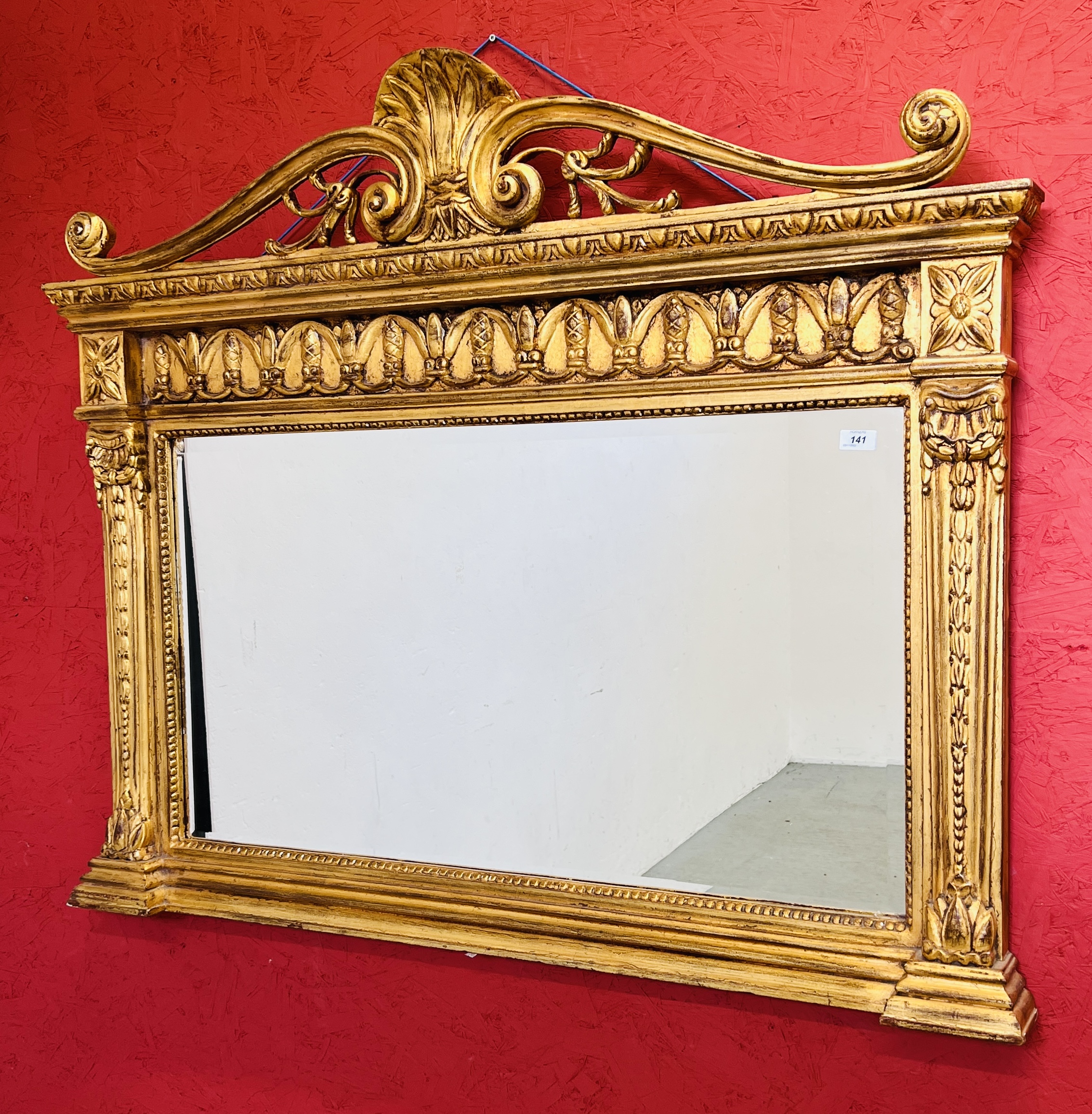 AN IMPRESSIVE GILT FINISH OVER MANTEL MIRROR WITH HEAVILY ORNATE DETAIL AND BEVELLED GLASS W 128CM,