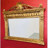 AN IMPRESSIVE GILT FINISH OVER MANTEL MIRROR WITH HEAVILY ORNATE DETAIL AND BEVELLED GLASS W 128CM,