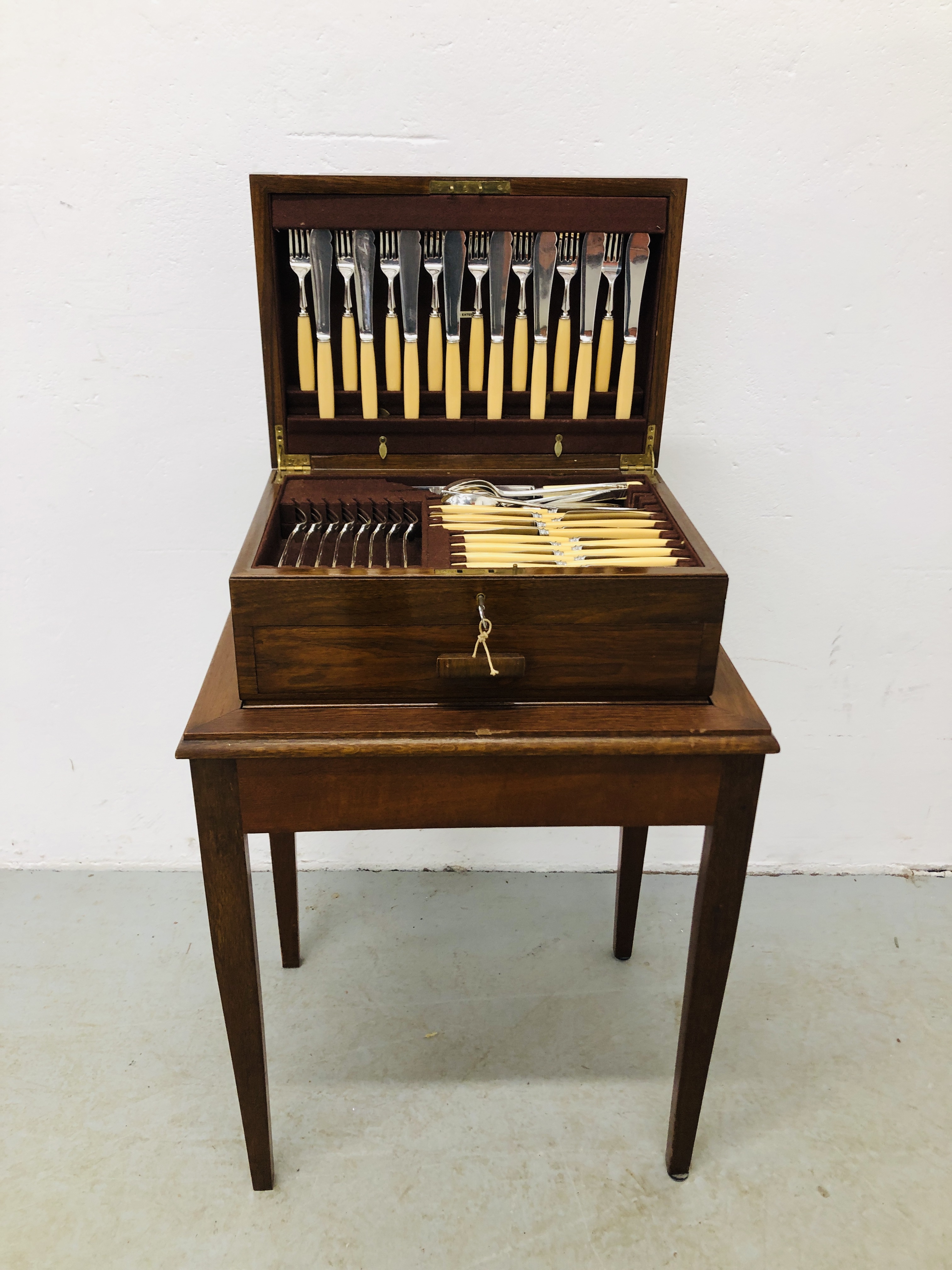 A MAHOGANY CANTEEN OF SILVER PLATED CUTLERY (NOT COMPLETE) ON MAHOGANY STAND