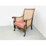 A PERIOD FRENCH BERGERE CHAIR WITH CARVED SCROLLED DETAIL AND CUSHIONED SEAT