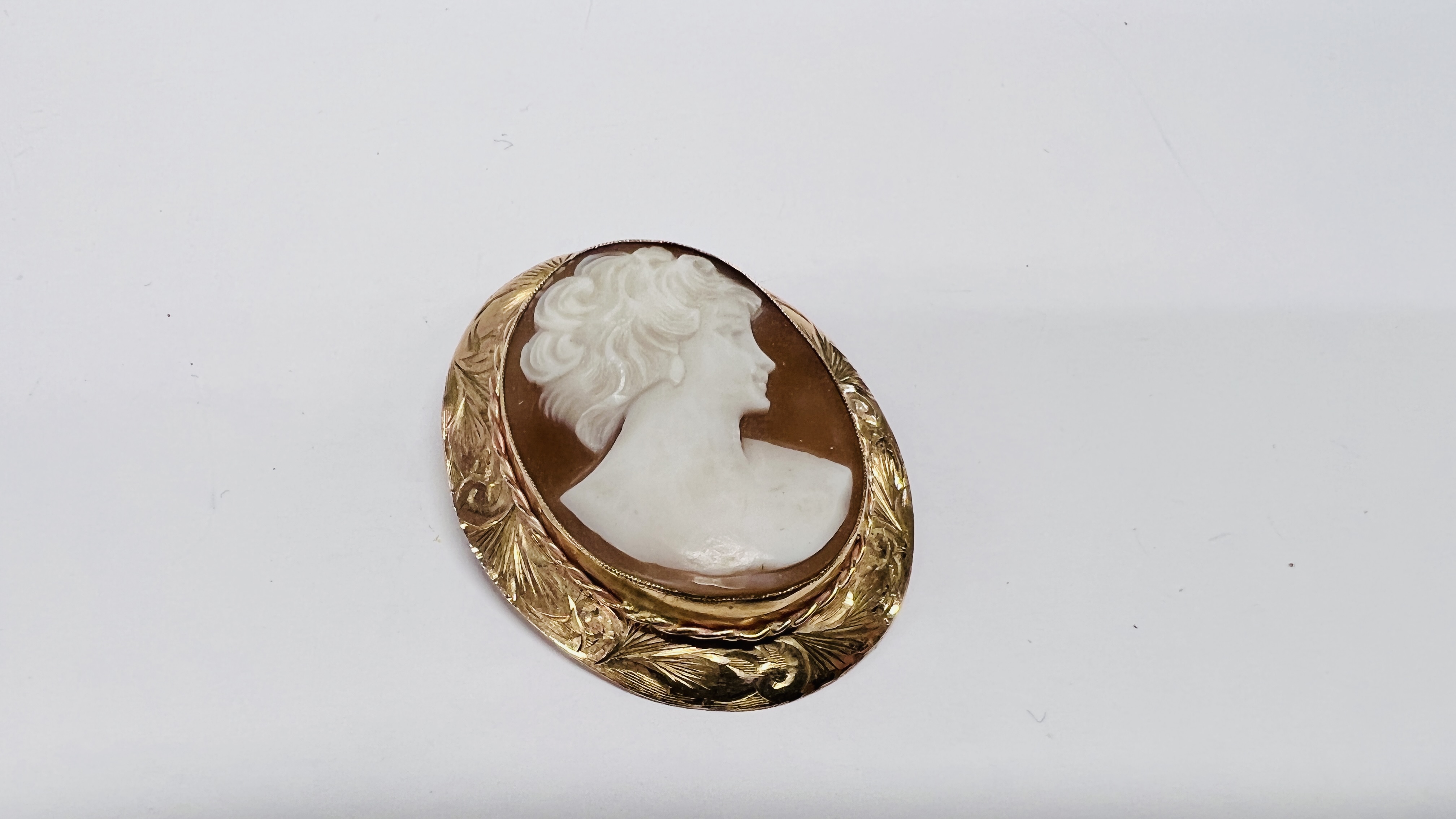 A SHELL CAMEO PENDANT / BROOCH IN 9CT GOLD FRAME.