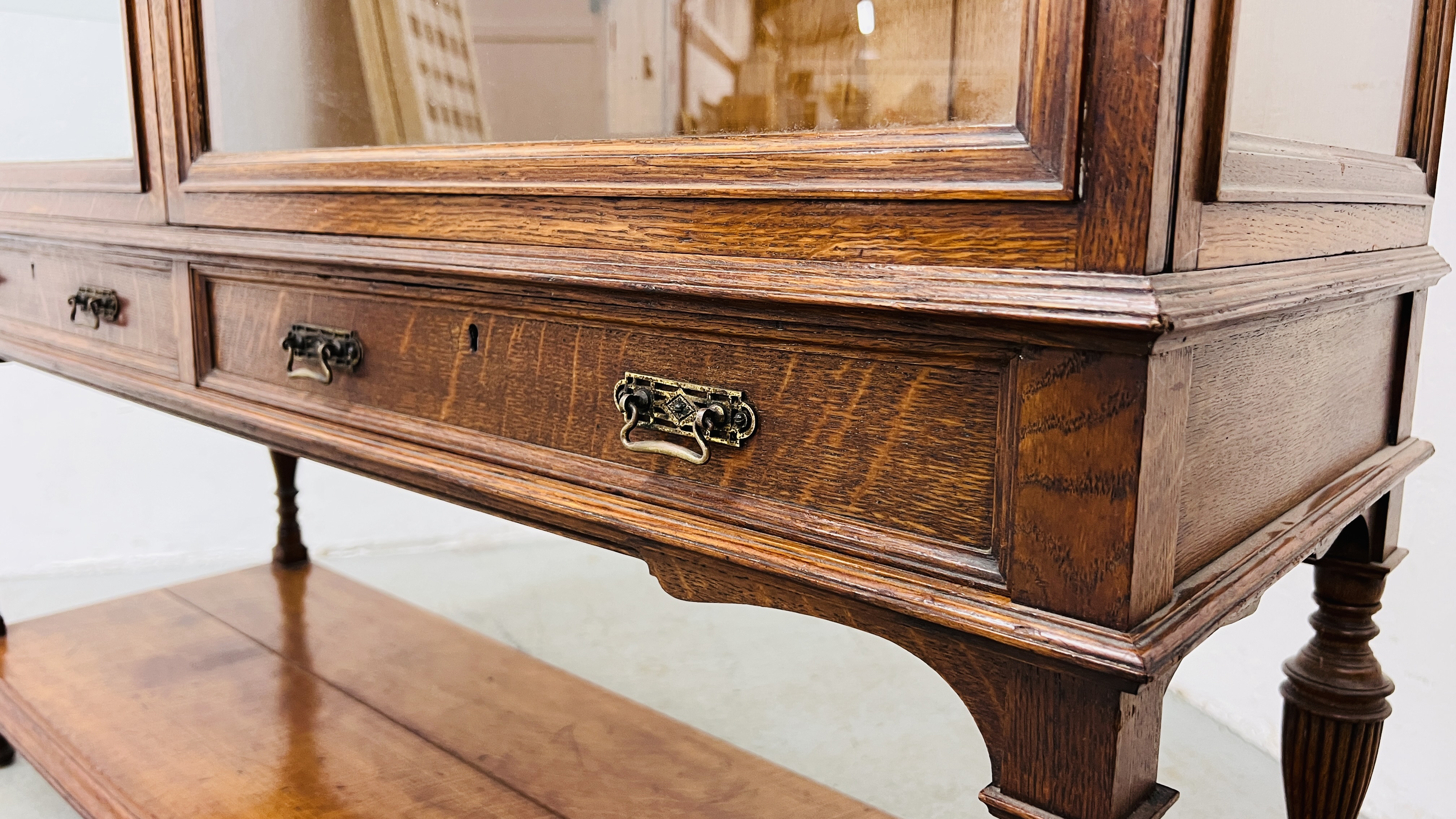 AN EDWARDIAN OAK GLAZED DISPLAY CABINET ABOVE A TWO DRAWER AND OPEN SHELF BASE WIDTH 122CM. - Image 8 of 20