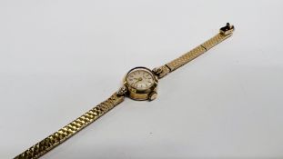 A LADY'S 9CT GOLD TISSOT WRISTWATCH WITH BATON NUMERALS, ON A 9CT GOLD BRACELET.