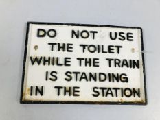 A REPRODUCTION CAST IRON "DO NOT USE THE TOILET WHILE THE TRAIN IS STANDING IN THE STATION" SIGN