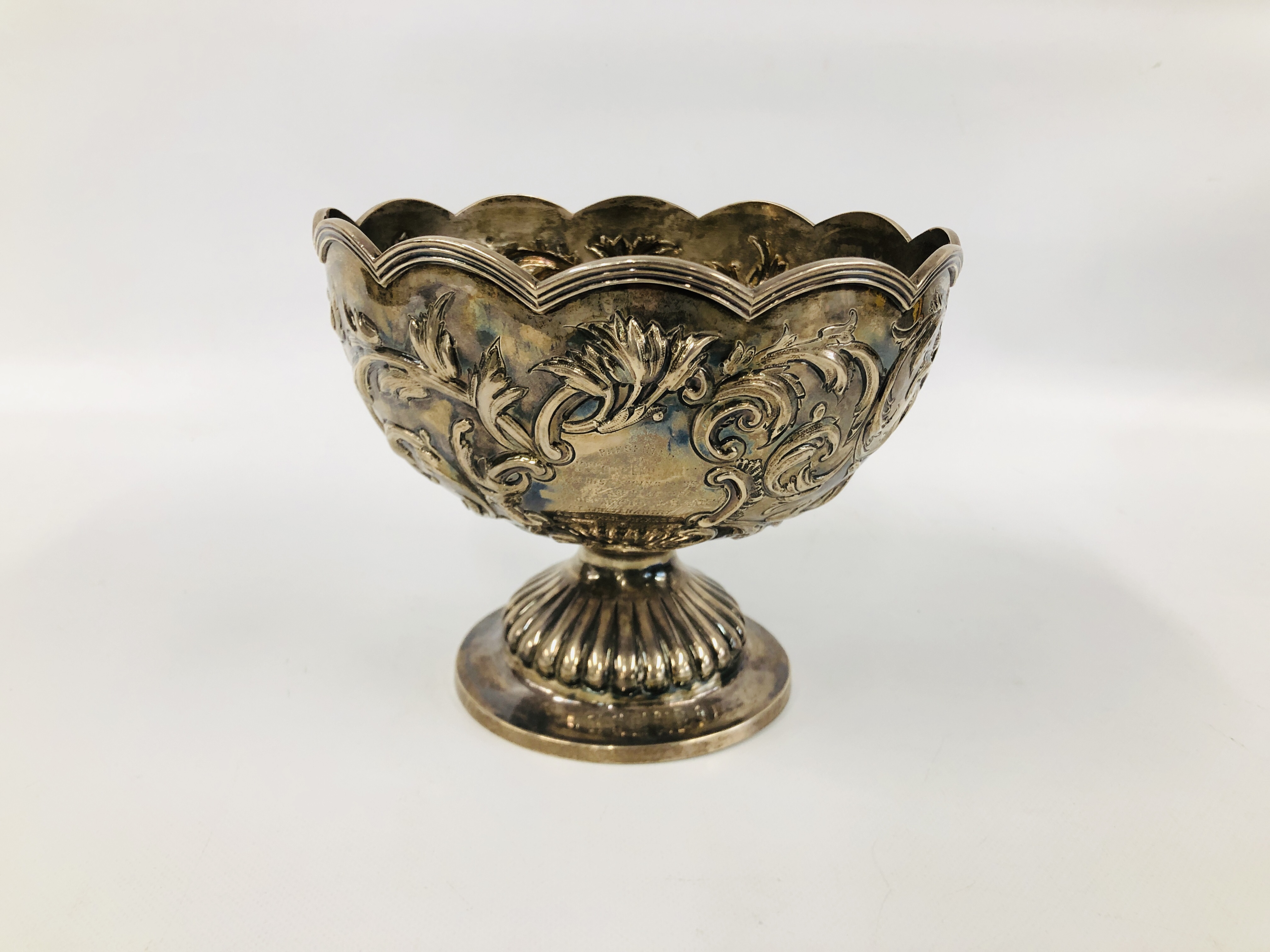 A VICTORIAN SILVER FOOTED ROSE BOWL THE WAVY RIM ABOVE SCROLLED LEAF DECORATION,