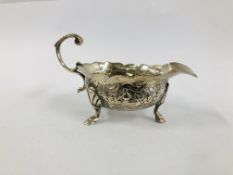 A GEORGE II SILVER CREAM BOAT WITH OPEN SCROLLED HANDLE THE BODY DECORATED WITH GEESE ON TRIPOD