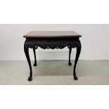 AN ANTIQUE MAHOGANY IRISH SIDE TABLE WITH MOULDED TOP ABOVE DETAILED CARVED DESIGN ON CLAW FEET