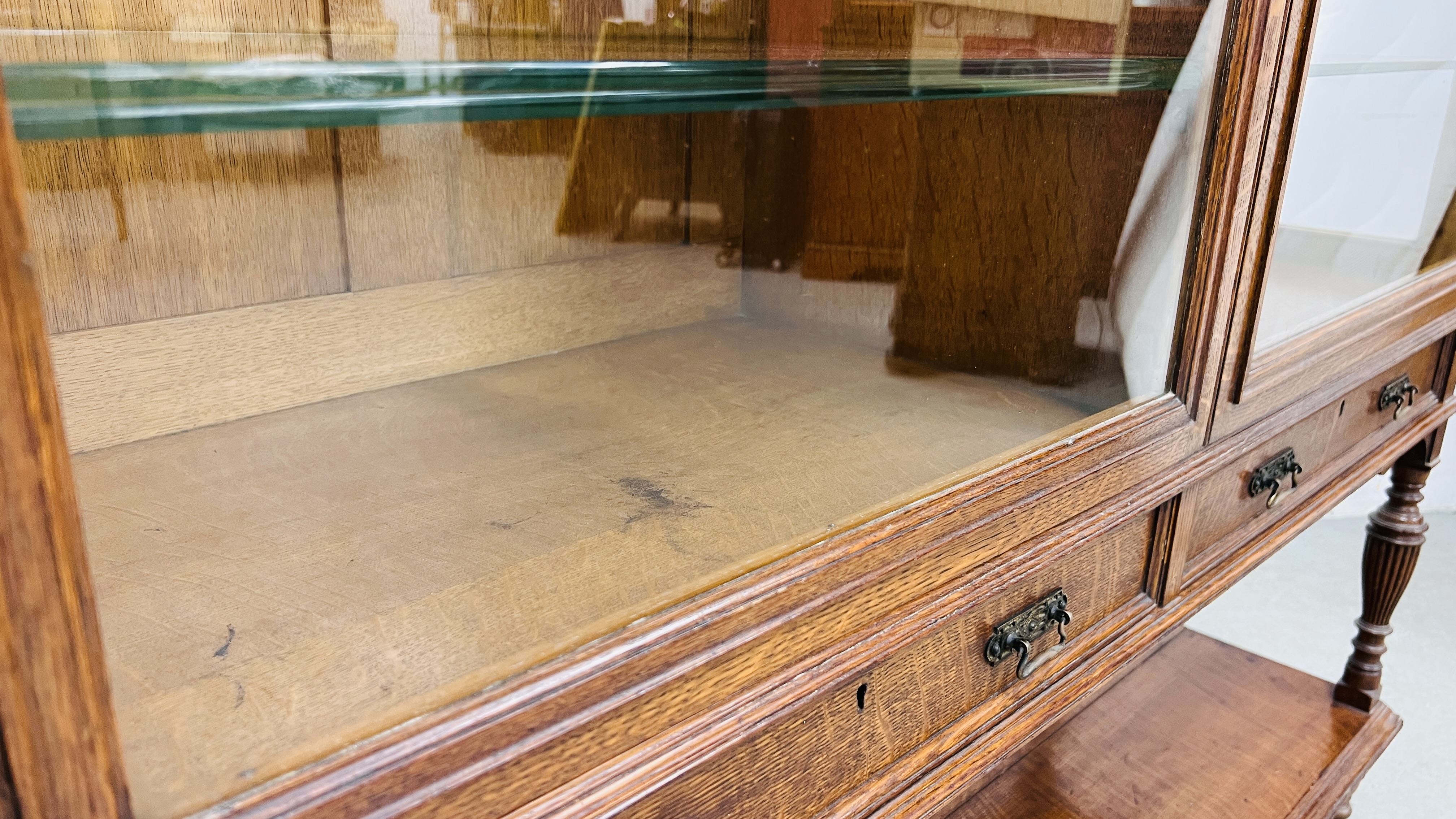 AN EDWARDIAN OAK GLAZED DISPLAY CABINET ABOVE A TWO DRAWER AND OPEN SHELF BASE WIDTH 122CM. - Image 18 of 20