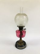 A TWIN BURNER TABLE OIL LAMP WITH CRANBERRY GLASS FONT AND ETCHED GLOBE SHADE