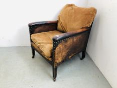 AN ANTIQUE LEATHER ARMCHAIR WITH STUD DETAIL