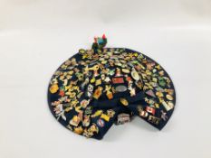 AN EXTENSIVE COLLECTION OF ENAMELLED BADGES DISPLAYED UPON A NAVY BLUE HAT