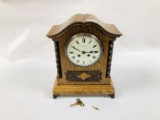 A SOLID OAK MANTEL CLOCK HAVING SHAPED PEDIMENT ,