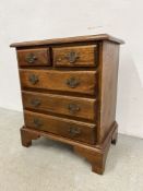 A REPRODUCTION MINIATURE OAK TWO OVER THREE CHEST OD DRAWERS WIDTH 50CM. DEPTH 32CM. HEIGHT 59CM.