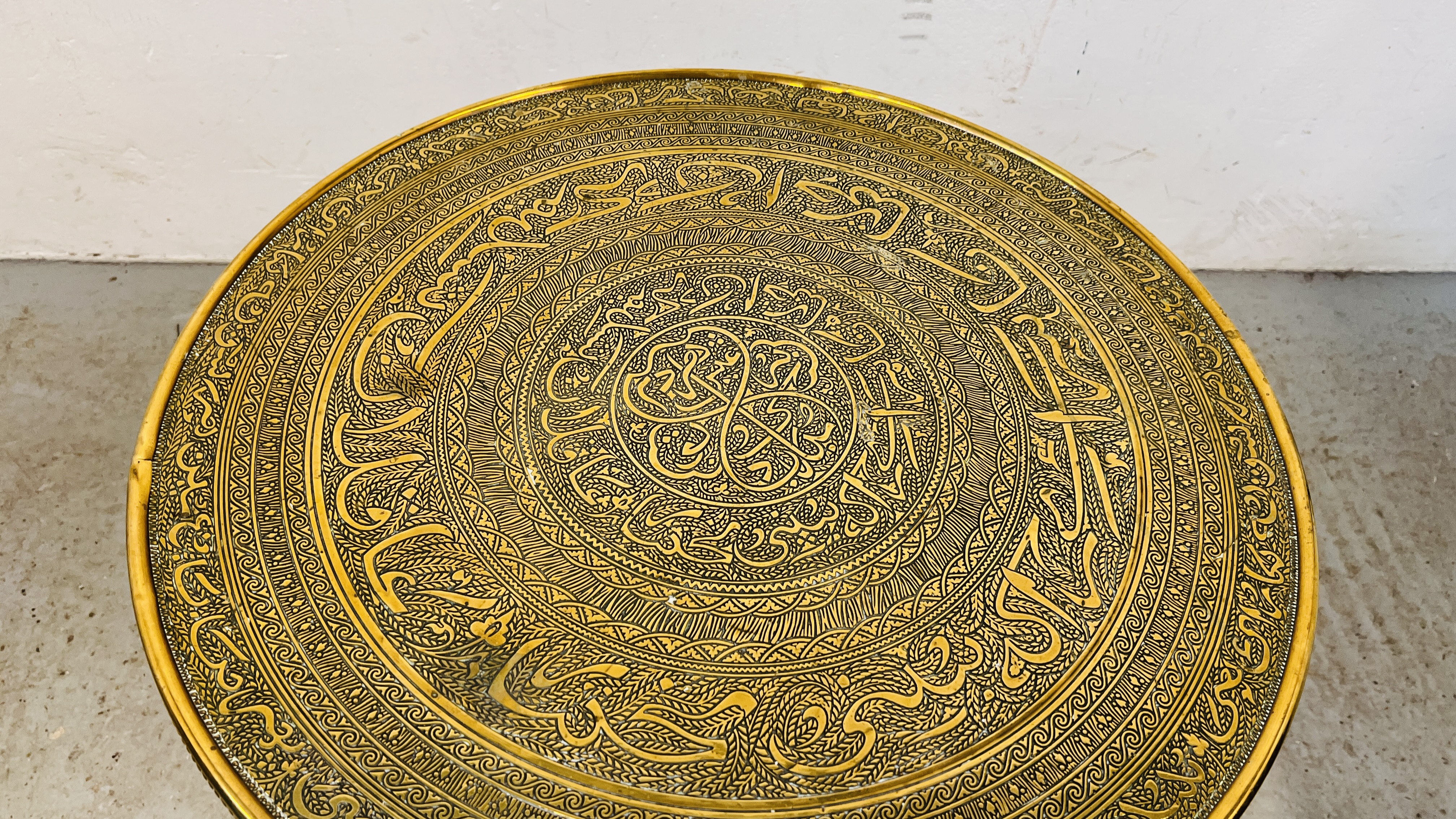 A CIRCULAR BRASS TOP OCCASIONAL TABLE WITH IRANIAN DESIGN ON FOLDING OAK BASE DIA. 59CM. - Image 3 of 5