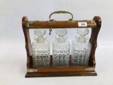 A VINTAGE OAK THREE BOTTLE TANTALUS WITH KEY