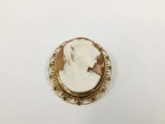 A VINTAGE YELLOW METAL CAMEO PENDANT BROOCH IN AN ORNATE OVAL SETTING, W 5CM X H 6CM.