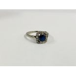 A ELEGANT VINTAGE RING SET WITH A CENTRAL BLUE STONE SURROUNDED BY DIAMONDS IN A SQUARE SETTING