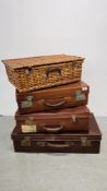 A GROUP OF THREE VINTAGE SUITCASES ALONG WITH A WICKER PICNIC BASKET