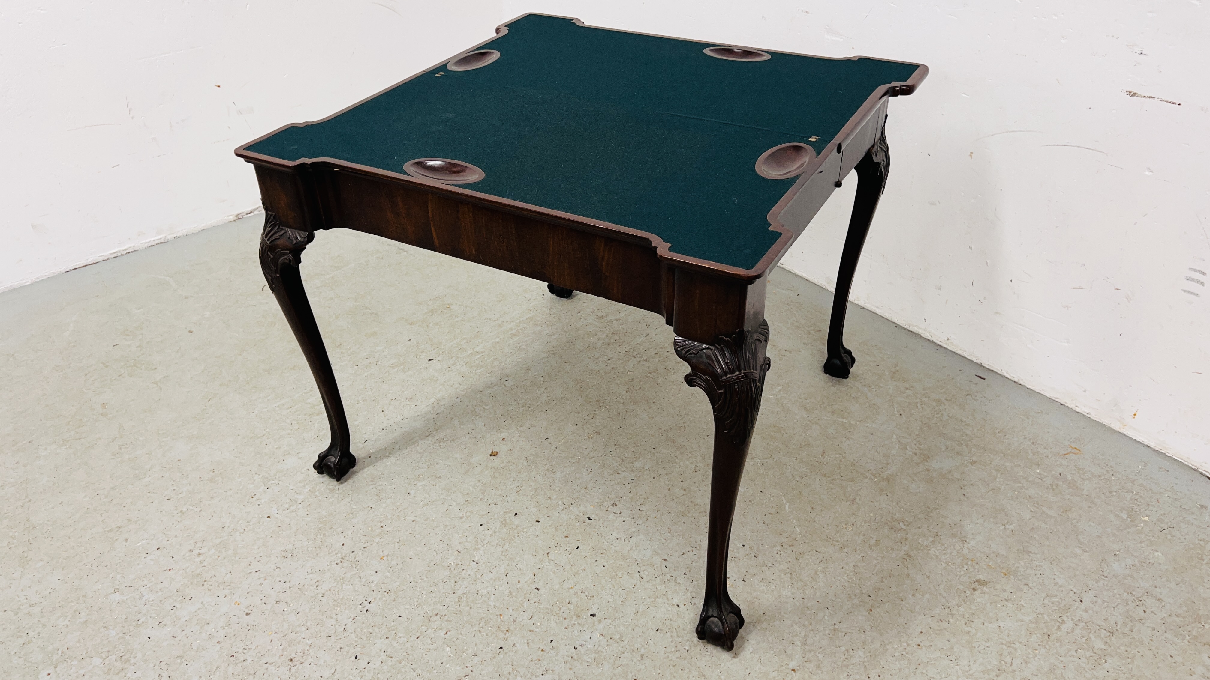 A GEORGE III MAHOGANY GAMING TABLE, THE TOP WITH GUINEA WELLS AND CANDLE CORNERS,