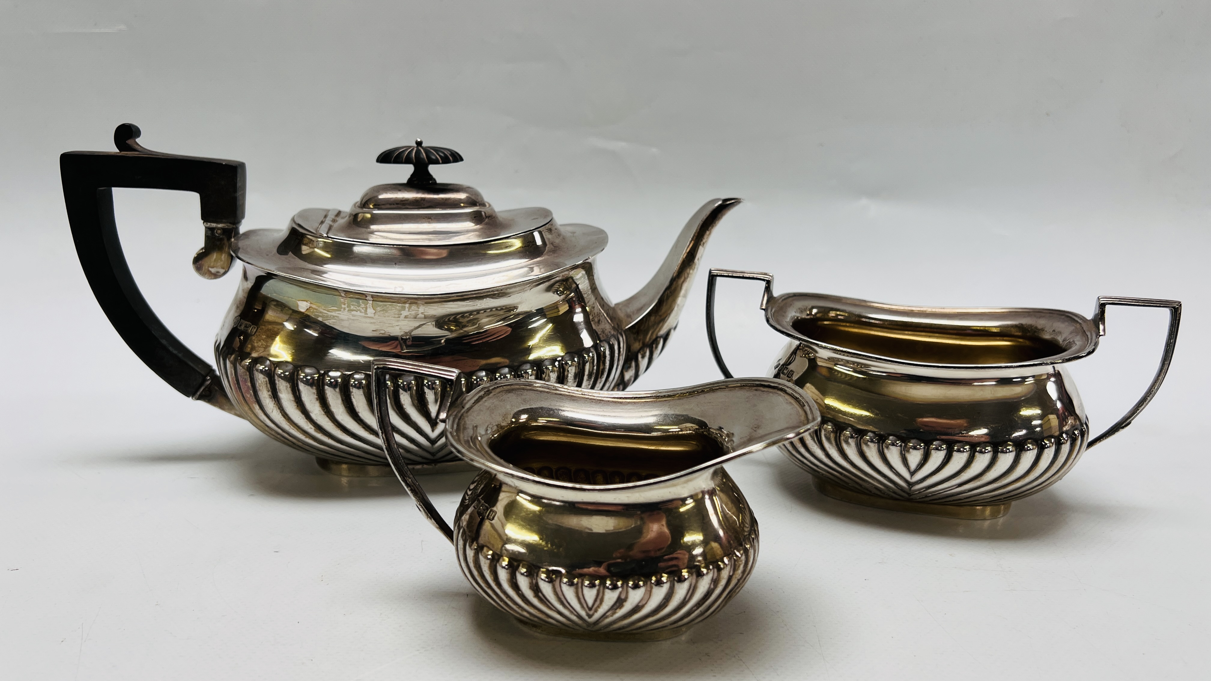 A THREE PIECE SILVER TEASET OF DRAGOONED DESIGN SHEFFIELD 1912