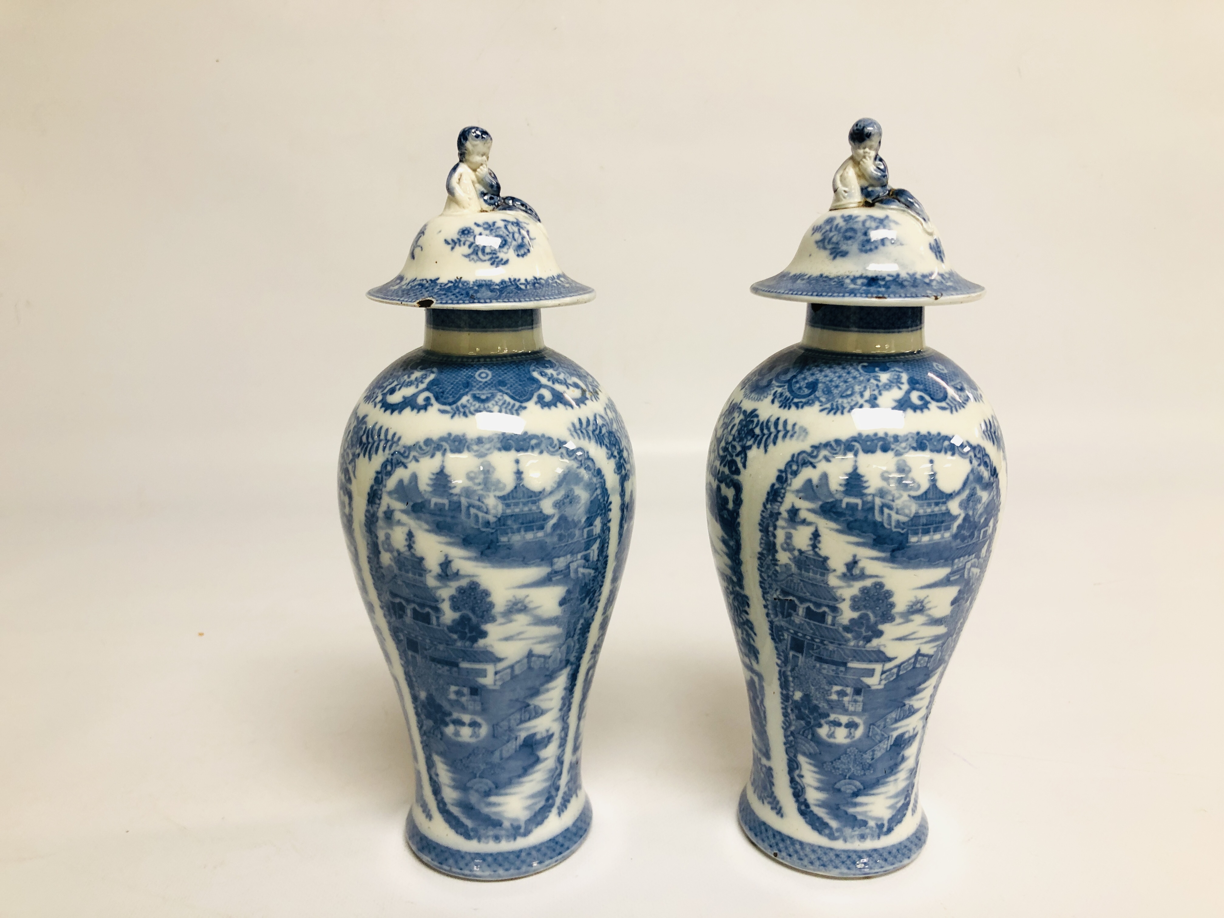 A PAIR OF CHINESE BLUE AND WHITE BALLUSTER VASES AND COVERS C.1800 A/F HEIGHT 28CM.