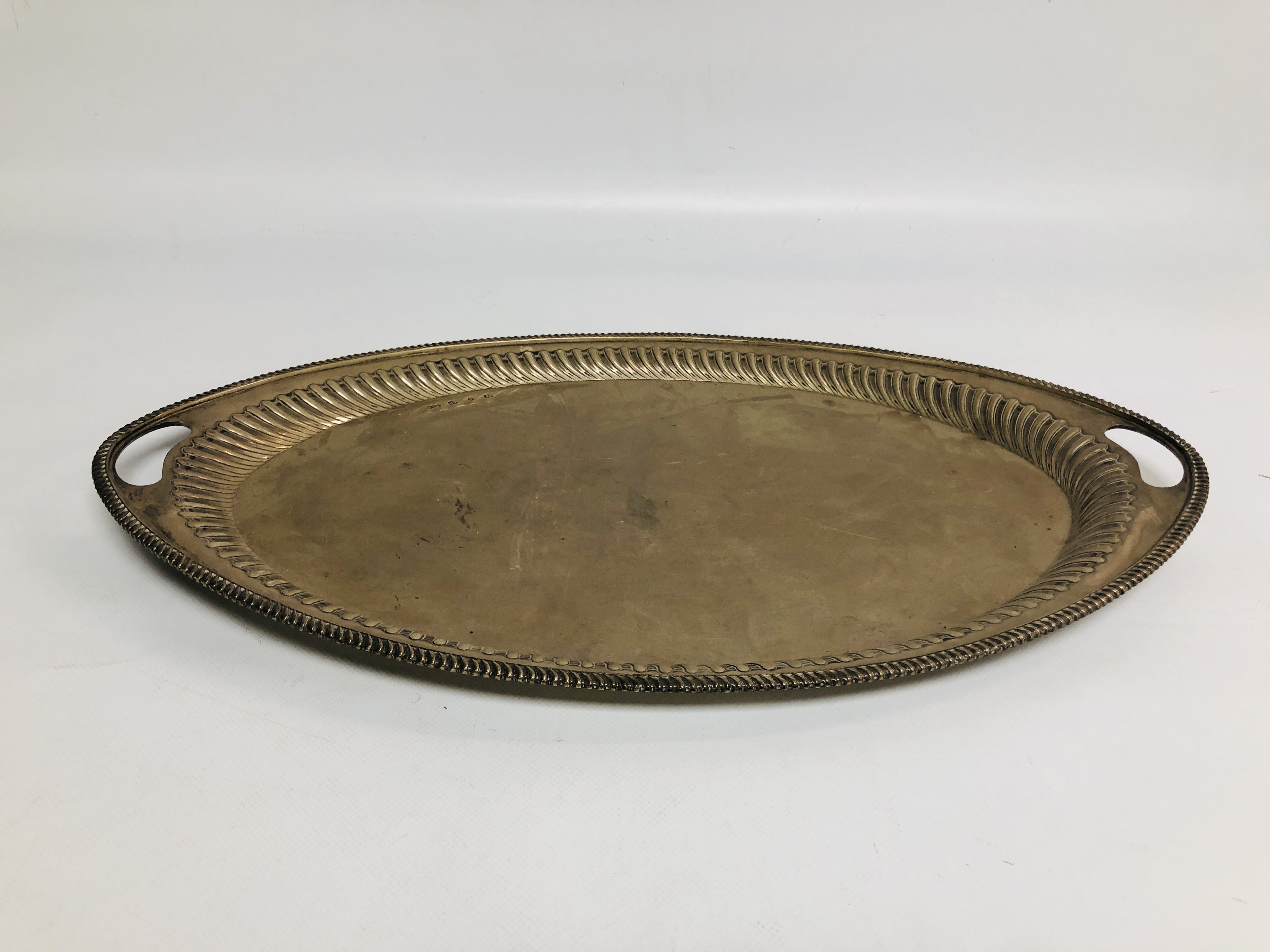 A SILVER TWO HANDLED OVAL TRAY WITH GADROONED DECORATION, SHEFFIELD 1916, L 56CM.