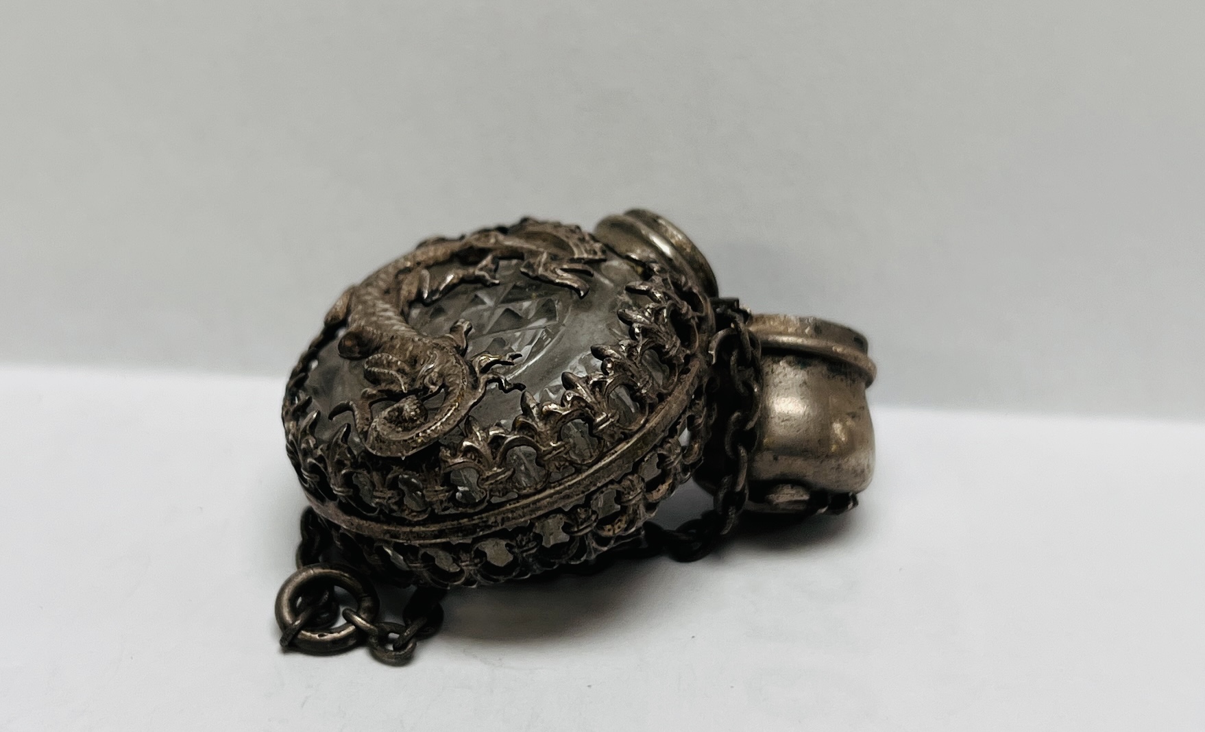 A MINIATURE ANTIQUE CUT GLASS SCENT BOTTLE ENCASED IN AN ORIENTAL WHITE METAL HOLDER - Image 7 of 7
