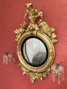 A REGENCY GILT CONVEX MIRROR WITH CANDLE ARMS, HEIGHT OVERALL 101CM.
