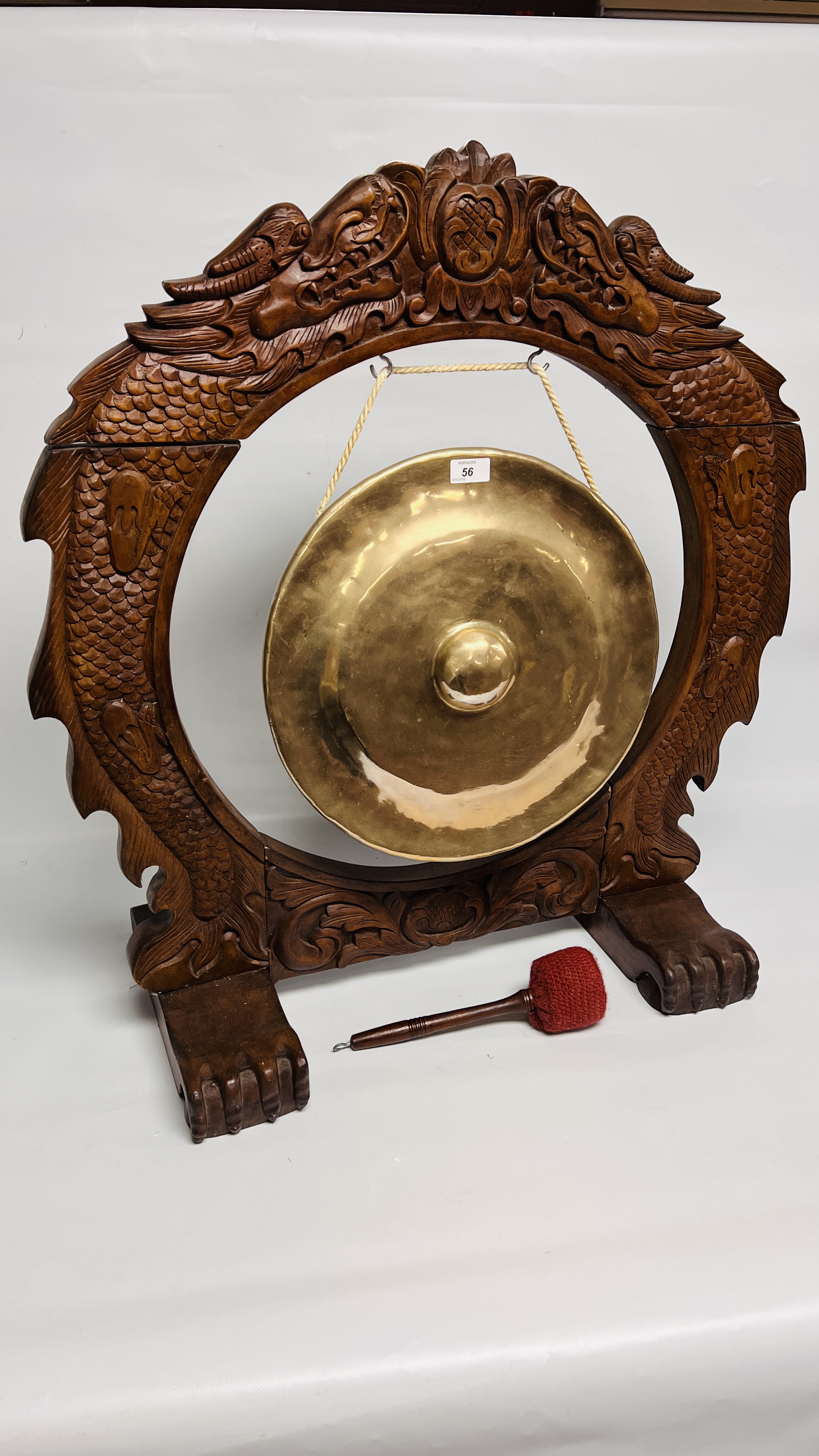 A LARGE BRASS GONG IN HEAVY CARVED WOODEN FRAME ON FEET (WITH GONG)