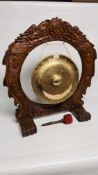 A LARGE BRASS GONG IN HEAVY CARVED WOODEN FRAME ON FEET (WITH GONG)