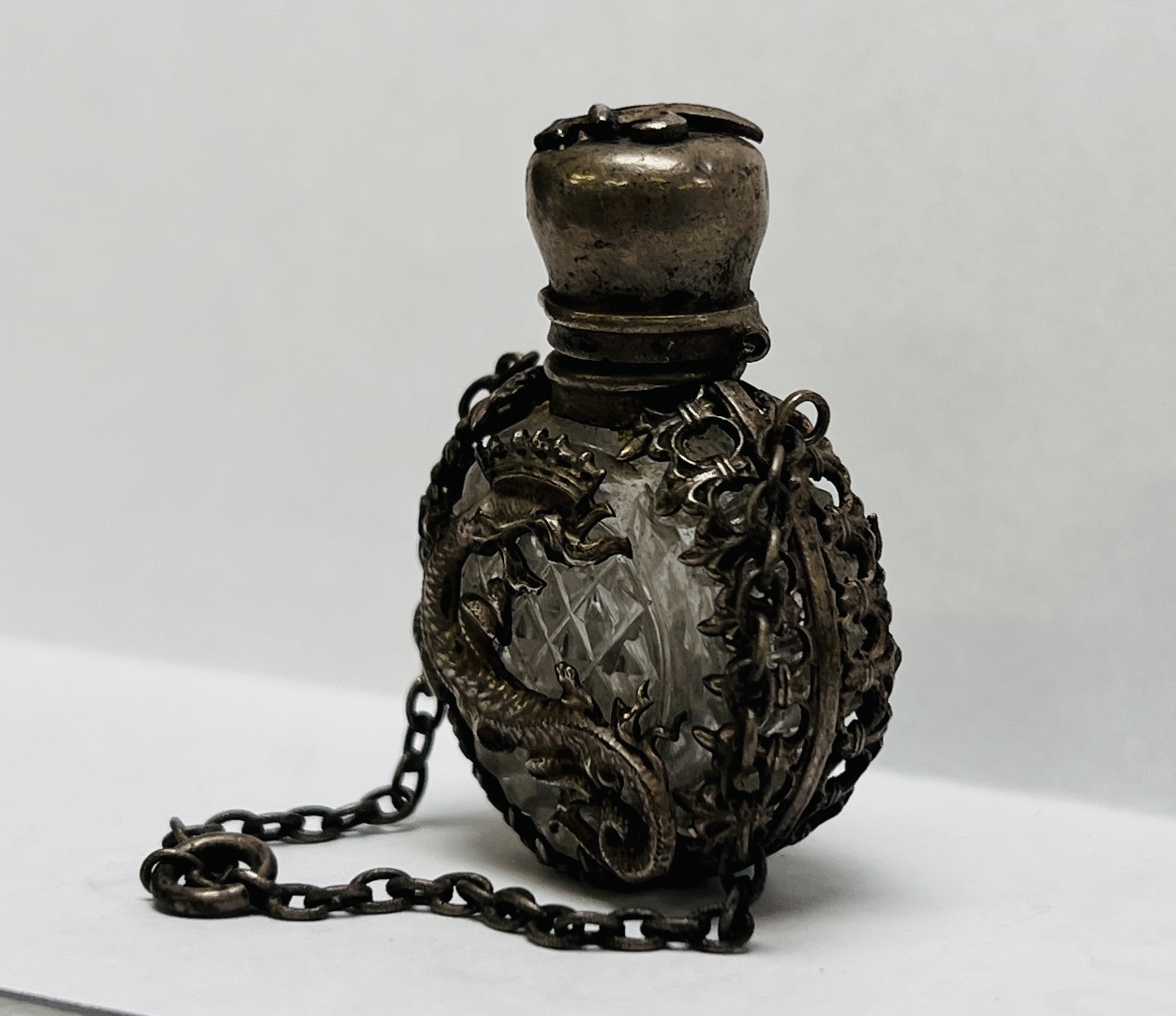 A MINIATURE ANTIQUE CUT GLASS SCENT BOTTLE ENCASED IN AN ORIENTAL WHITE METAL HOLDER - Image 2 of 7