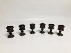 A SET OF SIX EARLY C19TH. LUGNUM VITAE EGG CUPS HEIGHT 8CM.