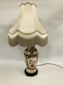 A CHINA BALUSTER SHAPE TABLE LAMP WITH FLORAL DECORATION AND FRINGED SATIN SHADE,