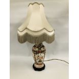 A CHINA BALUSTER SHAPE TABLE LAMP WITH FLORAL DECORATION AND FRINGED SATIN SHADE,