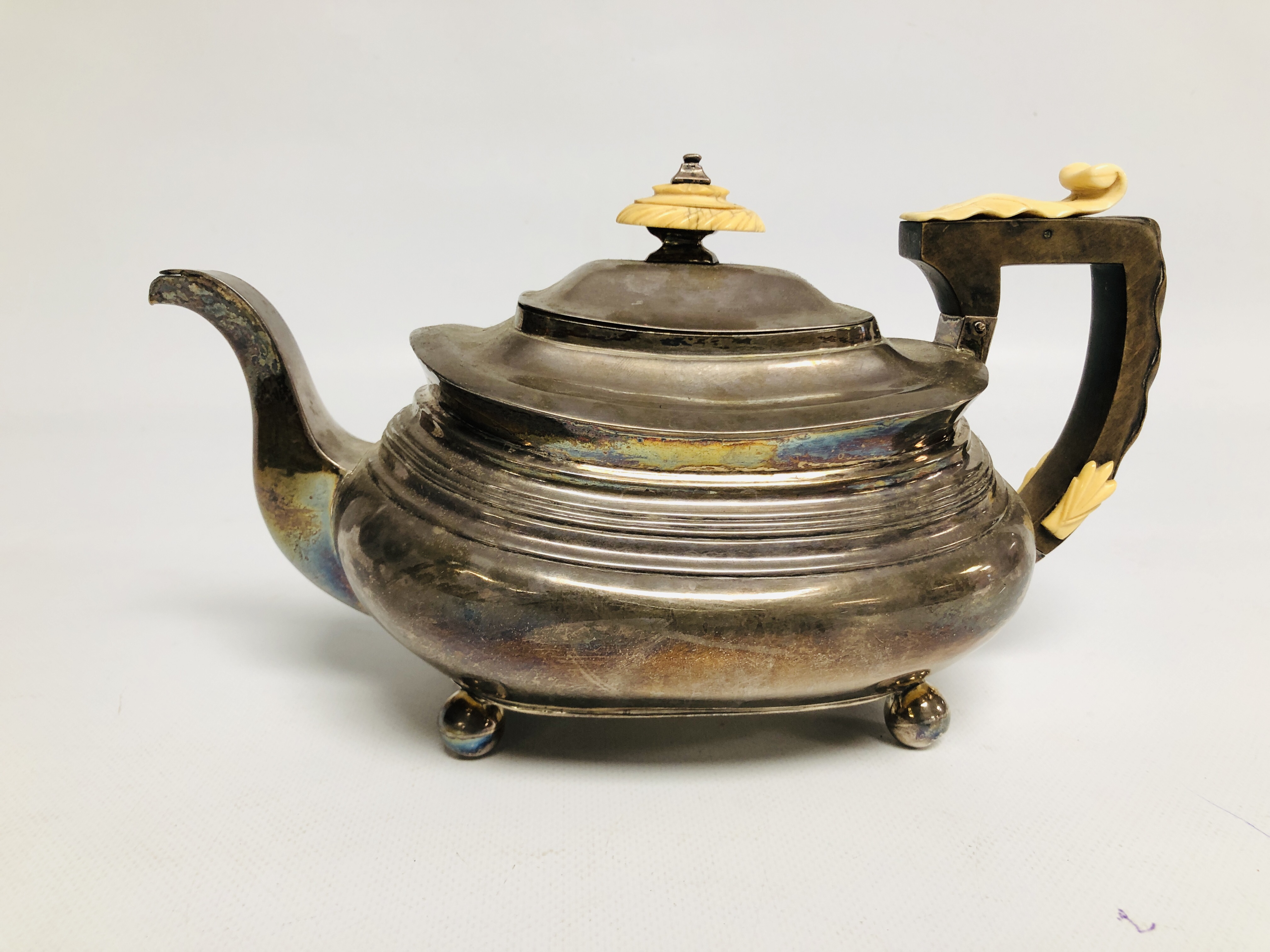 A GEORGE III SILVER TEAPOT, LONDON ASSAY OF COMPRESSED OVOID FORM ON BALL FEET.
