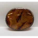A LARGE VINTAGE OVAL WHITE METAL BROOCH SET WITH AGATE WIDTH 8CM. HEIGHT 6.5CM.