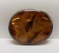 A LARGE VINTAGE OVAL WHITE METAL BROOCH SET WITH AGATE WIDTH 8CM. HEIGHT 6.5CM.