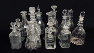 A GROUP OF 11 ANTIQUE GLASS SPIRIT DECANTERS TO INCLUDE GEORGIAN RING NECKED AND FACETED EXAMPLES