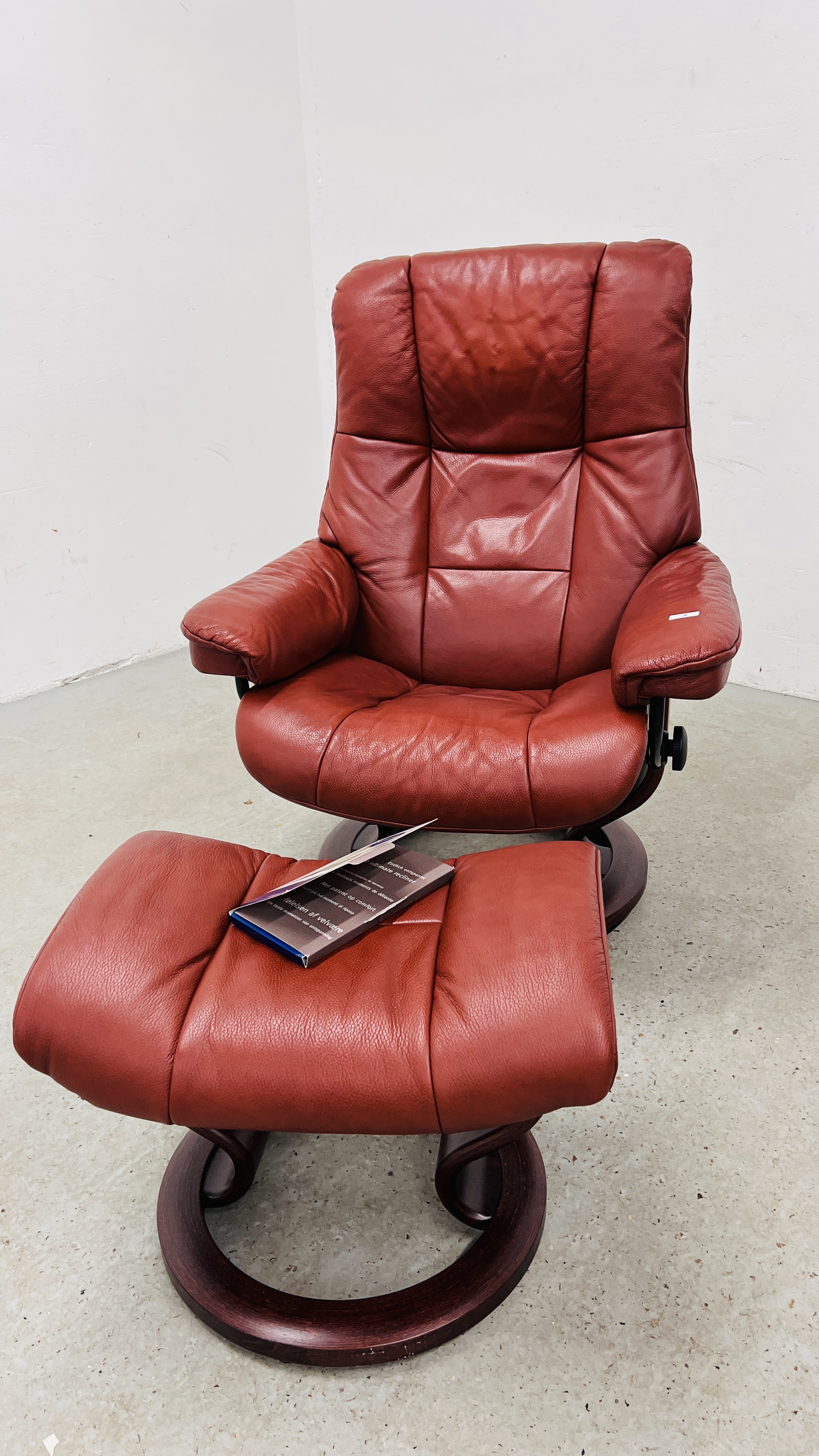 A GOOD QUALITY STRESSLESS RED LEATHER RELAXER CHAIR WITH MATCHING FOOTSTOOL.